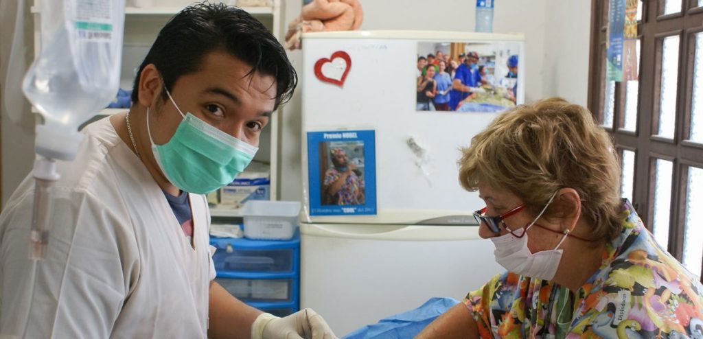 Isla Animal doctor Arutor Dzul operating on a rescue dog with a volunteer